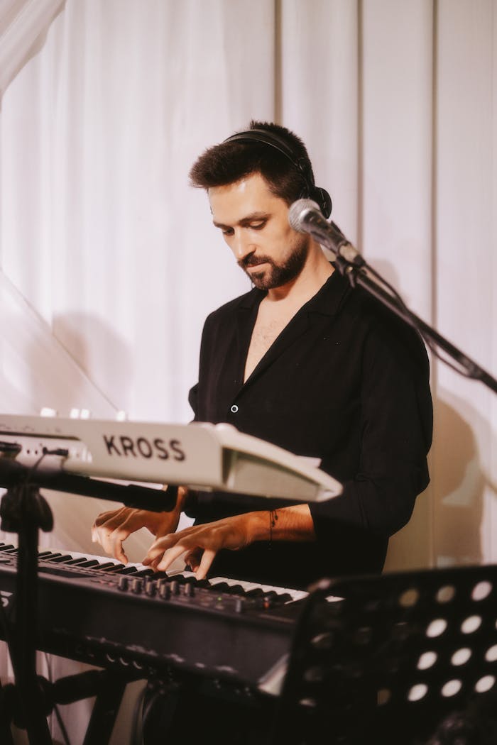 Young male musician performing with a keyboard and microphone indoors.